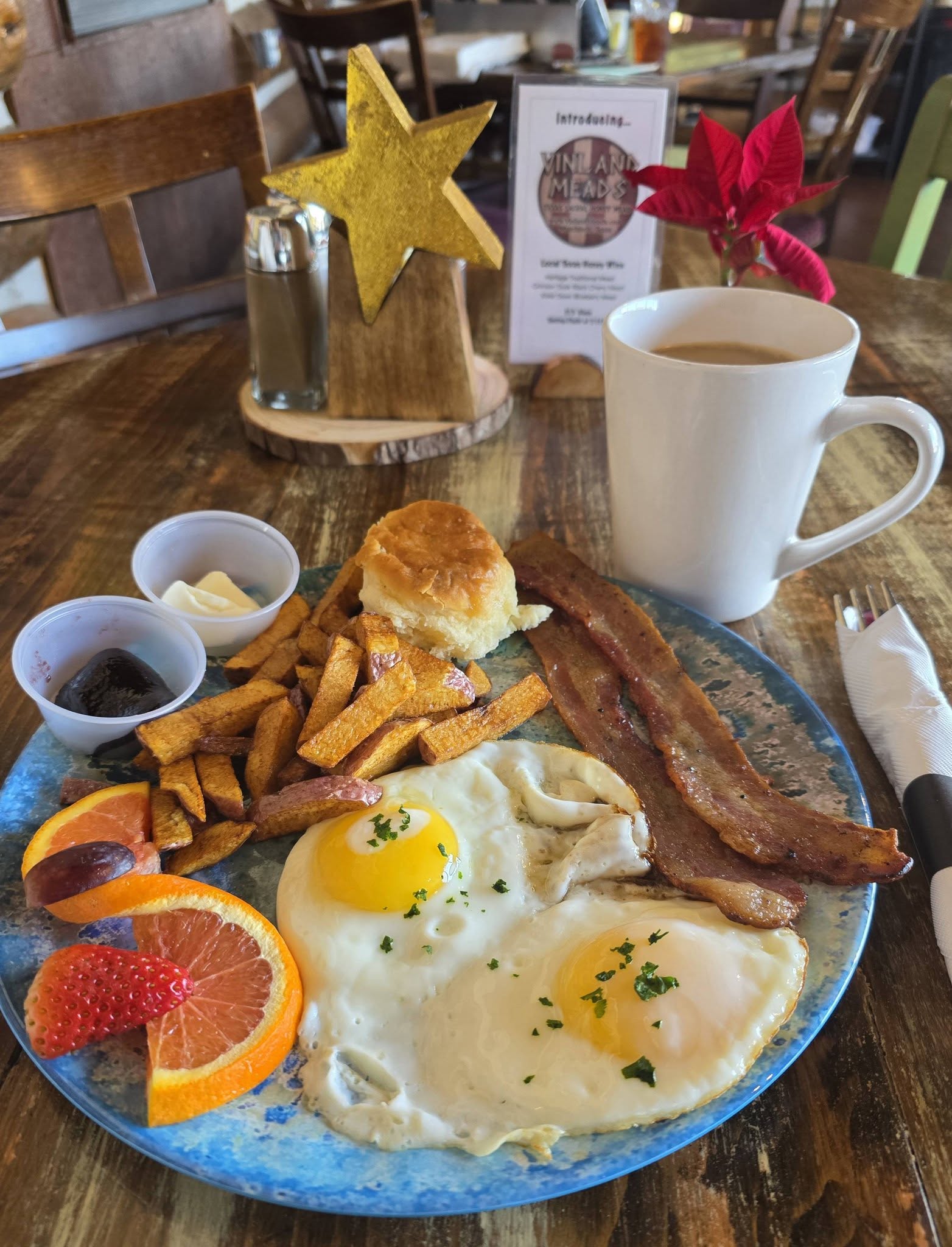 All day breakfast plate with eggs, bacon, home fries, and a biscuit