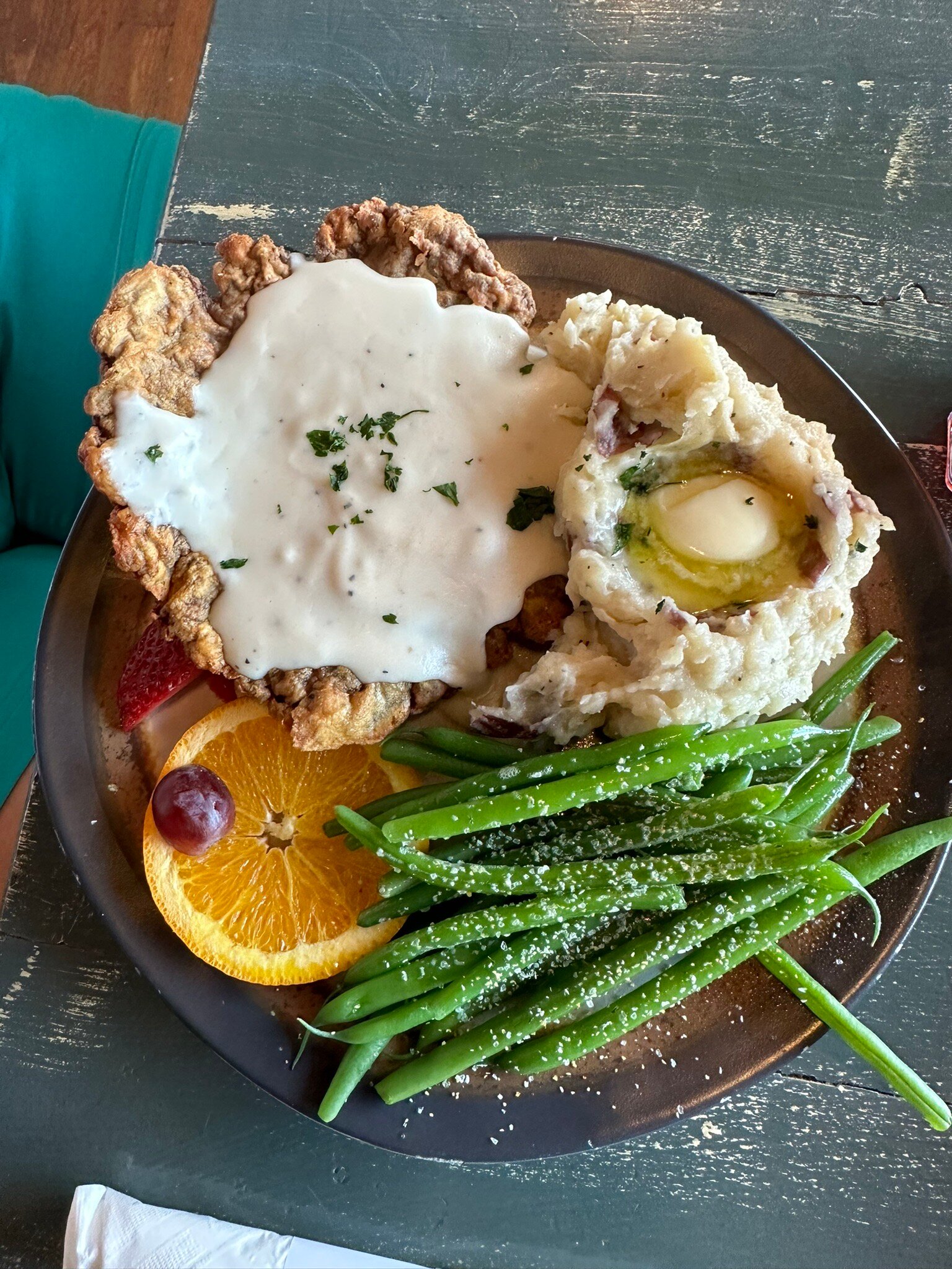 Chicken fried steak with cream gravy, mashed potatoes, and green beans