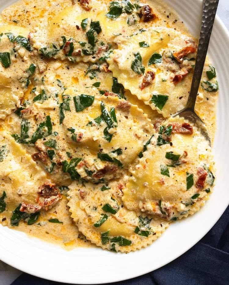 Ravioli in a cream sauce with spinach and sun-dried tomato