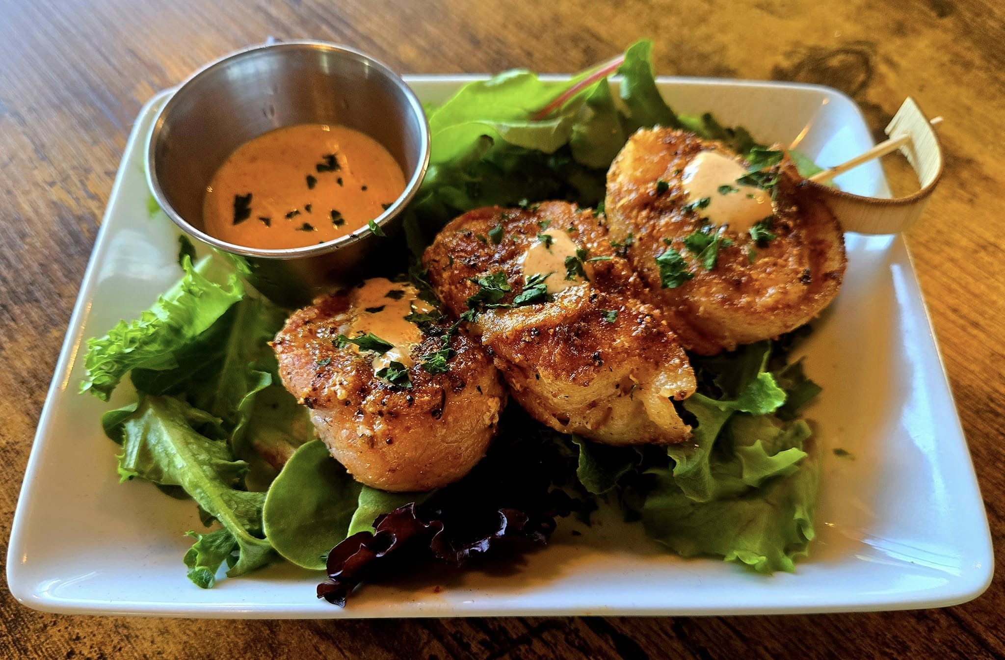 Seared scallops appetizer over mixed greens